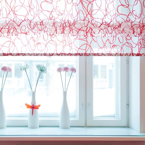 Cozy home interior concept in pastel colors. Three vases with flowers on a windowsill